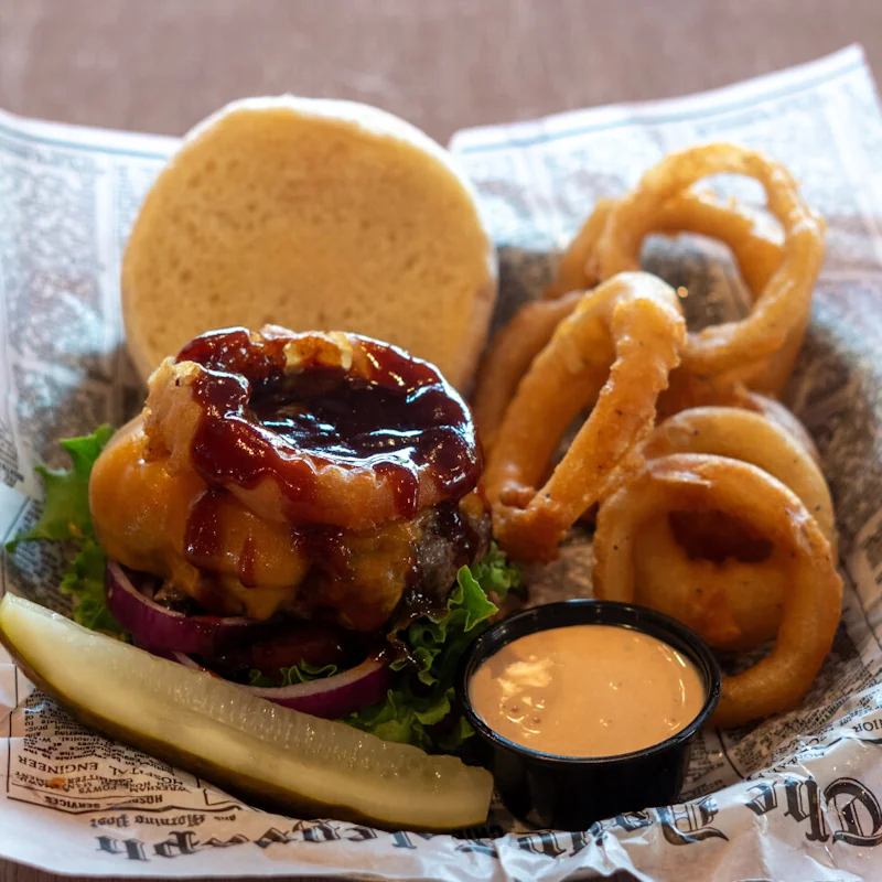 BBQ burger topped with bacon, onion ring, and cheddar, served with onion rings