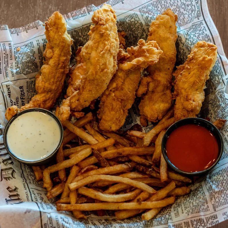 Golden-brown breaded chicken tenders with dipping sauce