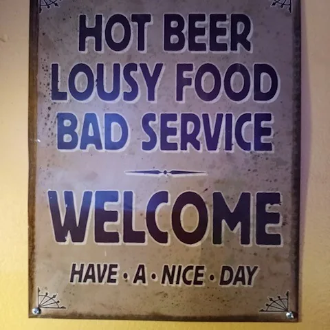 Hand-painted sign on the wall at Mangy Dawg